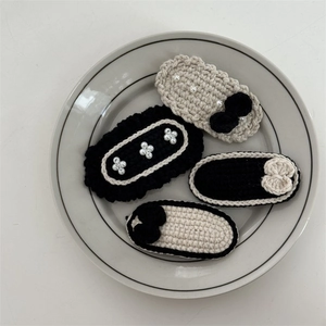 Detail of 4-piece handmade crochet BB hair clips with pearls and bows in black and beige