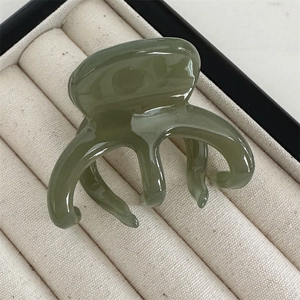 Detailed view of the glossy Morandi grey-green acetate five-tooth octopus hair claw clip