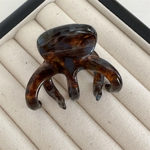 Macro detail of tortoiseshell texture and glossy finish on French hair claw clip