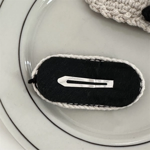 Detail view of oval crochet hair clip with black felt and silver metal snap closure