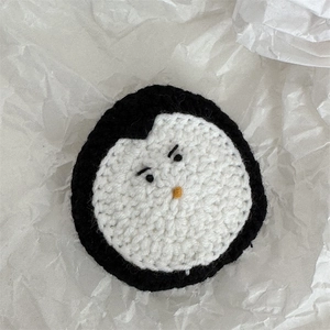 Détail de pince à cheveux pingouin crochetée main avec texture tricotée et visage