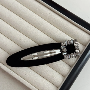Macro detail of black velvet BB hair clip with a square rhinestone buckle for women