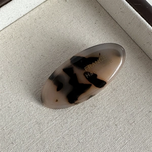 Macro view of oval tortoise shell acetate hair clip with gold France handmade logo