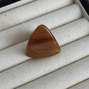 Détail de la pince à cheveux triangle en acétate ambré avec gravure France Handmade