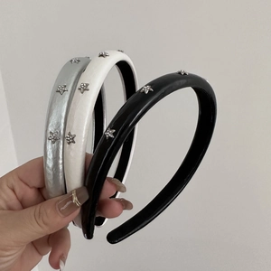 Chic padded star headband set in silver, cream, and black with sparkling rhinestone details