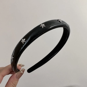 Close-up of black padded headband featuring silver stars with shimmering rhinestones