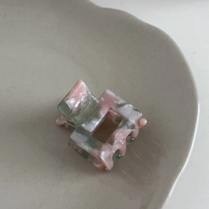 Detailed macro view of a pink marble acetate hair claw clip showing handmade craft details