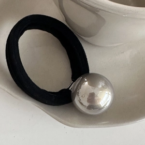 Detailed macro of a black elastic hair tie with a 2.5cm silver mirror metallic ball bead