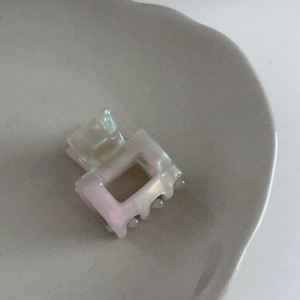 Detail of a handmade mini square acetate hair claw with pearlescent pink gradient