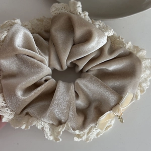 Champagne velvet scrunchie with lace edge and golden charm for elegant hair styling