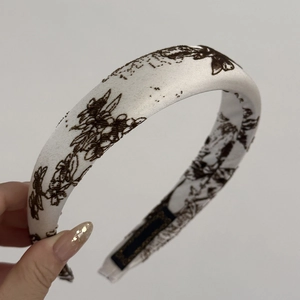 Detail of white satin headband with vintage coffee floral print and inner woven label