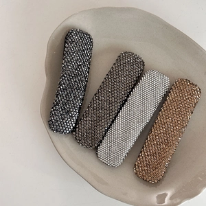 Sparkling rhinestone hair clip set in four colors displayed on a ceramic tray
