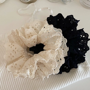 Detalle de coleteros de encaje crema y negro con bordado delicado y bordes ondulados