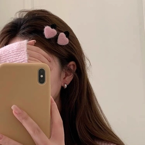 Sweet pink plush heart-shaped hair clips and silver hoop earrings on a model