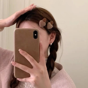 Brown fuzzy heart-shaped hair clips in plush material worn as a sweet pair for women