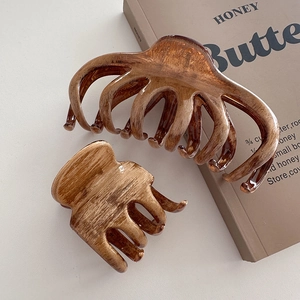 Set de pinces à cheveux en résine ambrée texture bois sur fond de livre stylé