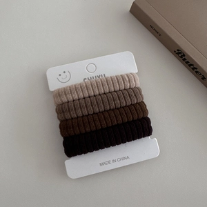 Détail d'élastiques à cheveux en tricot sans couture aux tons terre sur carte