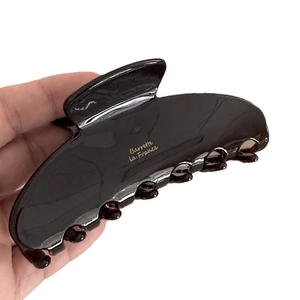 Pinza per capelli minimalista in acetato tartarugato scuro con logo dorato elegante