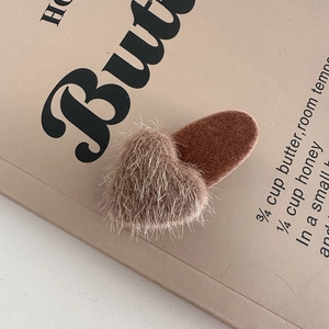 Close-up of a brown fuzzy plush heart hair clip with velvet duckbill base for women