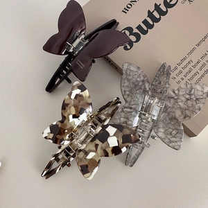 Three acetate butterfly hair claws in tortoiseshell, brown and grey marble texture patterns