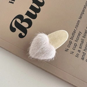 Close-up of soft fuzzy heart hair clip on aesthetic book background with recipe text