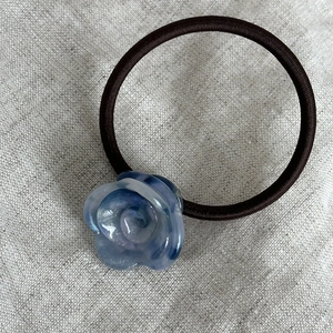 Elastico per capelli con rosa in acetato e trama marmorizzata blu su fondo di lino