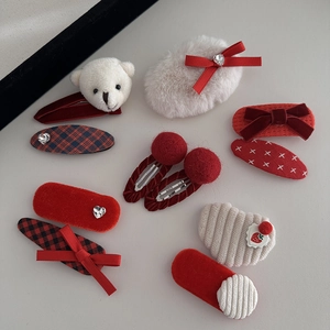 Flat lay of 10 festive red and white hair clips with plush bears and bows for girls