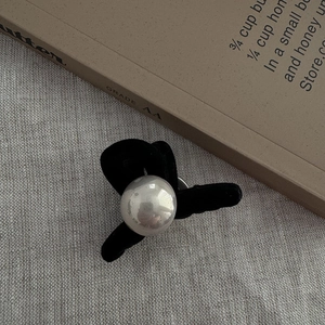 Detailed view of elegant black velvet flocking and large pearl on the shark hair claw