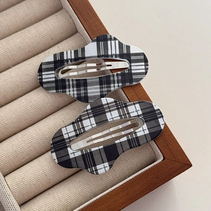 Detailed view of black and white plaid fabric cloud-shaped BB hair clips in a wooden box
