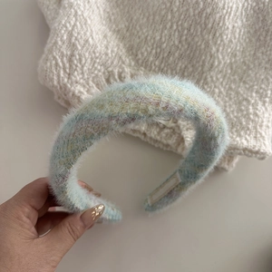 Detailed close-up of light blue fluffy headband with colorful mixed knit fibers