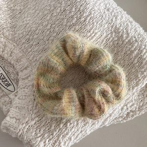 Close-up of fluffy colorful knitted hair scrunchie with soft pastel texture details