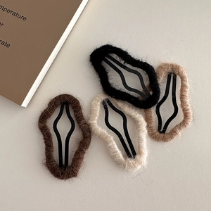 Detailed view of four plush cloud hair clips in earthy tones with soft wool textures