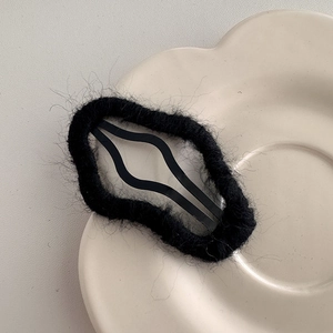Close-up of black plush cloud BB hair clip with soft fuzzy texture for autumn style