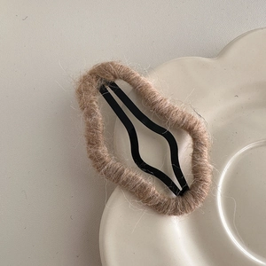 Detail of coffee brown mohair yarn wrapped around a metal BB hair clip for autumn style