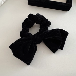 Detailed view of luxury black velvet hair scrunchie with large elegant bow and pearl pendant