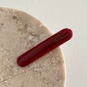 Détail de la barrette bordeaux en acétate avec gravure dorée France Handmade