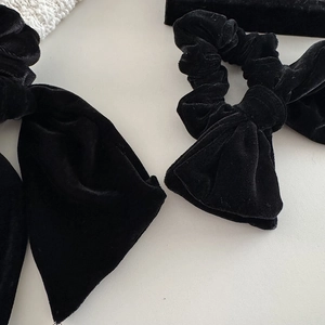 Elegant black velvet bow scrunchie with a soft texture and vintage luxury design