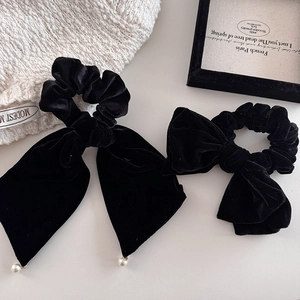 Detail of black velvet bow hair scrunchies with elegant artificial pearl pendant accents