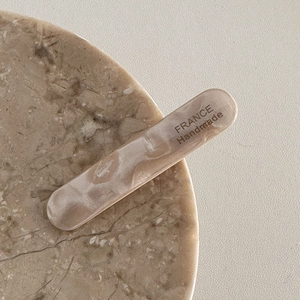 Détail de la barrette en acétate marbré beige avec gravure France Handmade