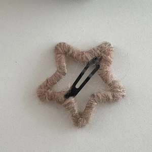 Detailed macro view of star-shaped hair clip with brown wool wrap and metal BB clip