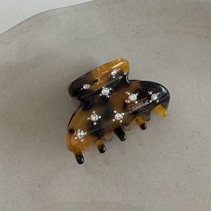 Dettaglio macro della molletta in acetato tartarugato fatta a mano con strass brillanti