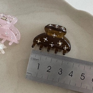 Dettaglio di fermagli per capelli in acetato da 4cm con strass e scala graduata