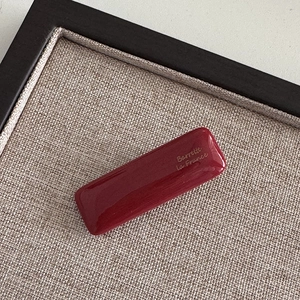 Detail of red marbled rectangular barrette with Barrette La France gold lettering