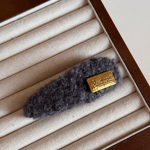 Détail de la barrette en polaire grise avec plaque dorée gravée Handmade et logo