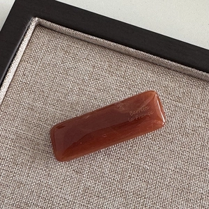 Detailed macro view of the dark amber resin barrette featuring the Barrette la France logo