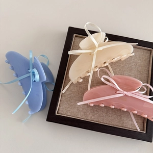 Dettaglio di grandi mollette per capelli color pastello blu, giallo e rosa
