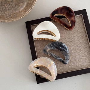 Detail showing four assorted leopard print acetate hair claws with gold metal frames