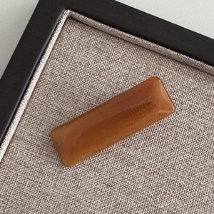 Detailed macro of a rectangular amber acetate hair clip with gold France Handmade logo
