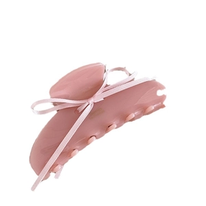 Pinza per capelli in resina rosa con fiocco di raso su sfondo bianco pulito