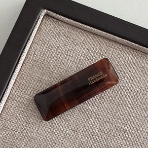 Macro detail of tortoiseshell acetate hair clip with a gold France Handmade logo